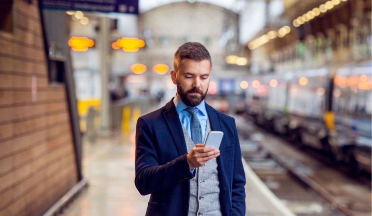Woman with phone in hand walking on a road